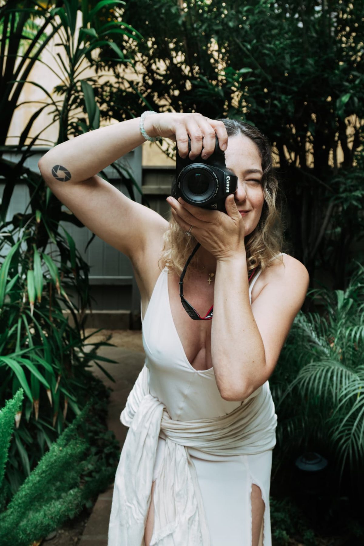 Simone Dib photographing with her camera in a garden